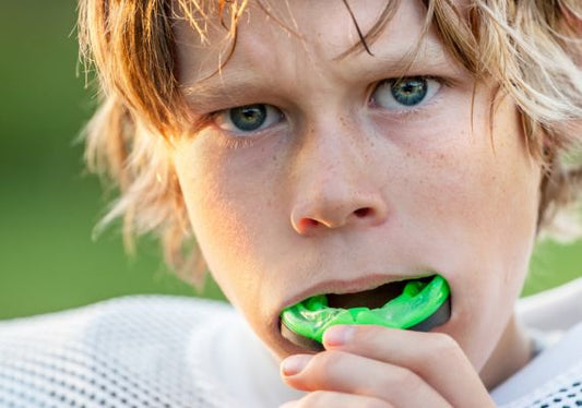An athlete putting a mouth guard in his mouth guard