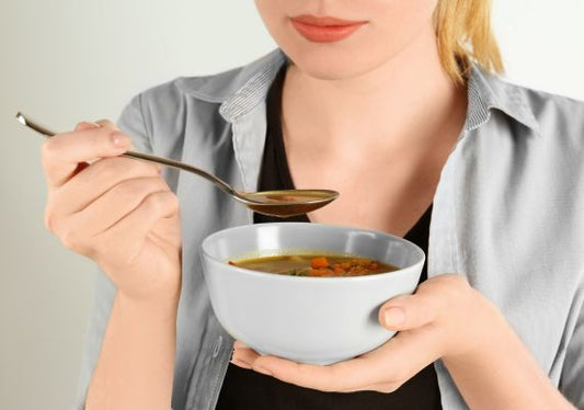 A woman eating soup after a root canal