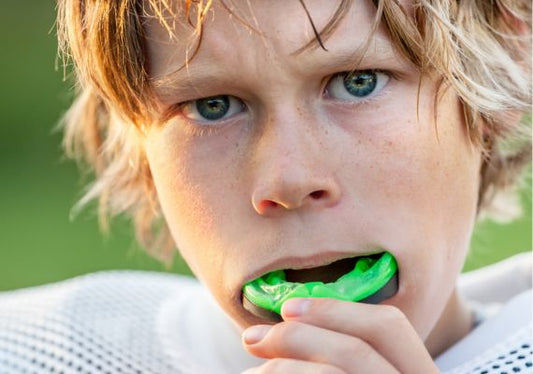 A close-up of a boy wearing a mouth guard before the game.