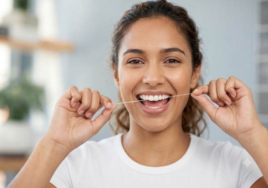 A woman is flossing her teeth 