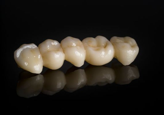 An image of a set of zirconia crowns with a black background.