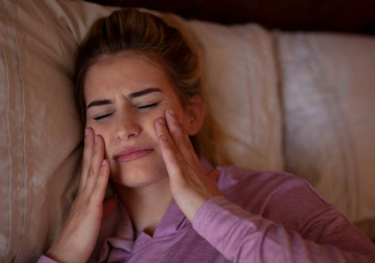 A woman experiencing pain after teeth grinding