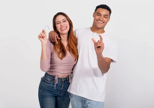 A man and a woman holding Caspersmile clear aligners while posing for a picture